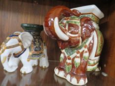 A ceramic elephant plant stand together with a smaller example