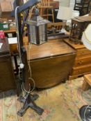 A oak drop leaf dining table together with a lantern style standard lamp