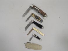 A collection of vintage fruit and pocket knives