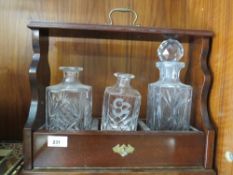 A modern three bottle tantalus and part contents