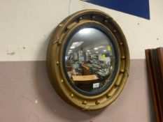 An antique gilt circular wall mirror