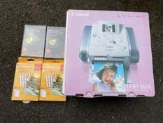 A boxed Cannon Selphy DS 810 compact photo printer and 4 packs of photopaper