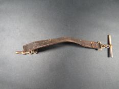 A hallmarked 9ct gold mounted t-bar and clasp on a leather strap