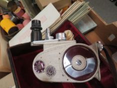 A tray of vintage photographic items to include a cased Bell & Howell cine camera