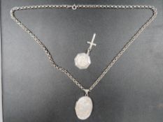 A locket on a silver chain together with a crucifix and a St. Christopher