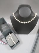 A boxed Beaverbrooks pearl type necklace interspersed with white metal bead having white gold
