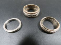 Two unmarked eternity rings together with a silver example