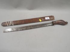 An Asian style machete with figurative carved wooden handle