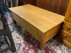 A modern light oak coffee table with lift up lid to reveal storage