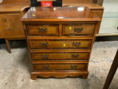 A small reproduction five drawer chest of drawers