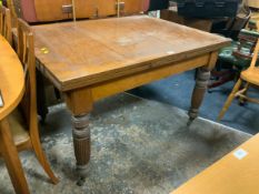 An Edwardian oak draw leaf dining table with fluted supports