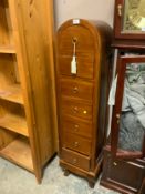 A modern small domed seven drawer chest