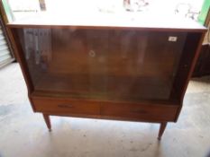 A retro teak glazed low bookshelf with sliding glass doors and two drawers