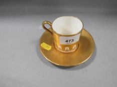An Aynsley heavily gilded coffee can and saucer with hand painted fruit design