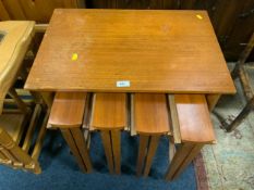 A mid-century teak nest of five tables on castors