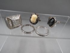Five silver and white metal rings