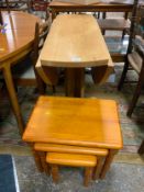 A solid light oak drop leaf table together with a pine nest of tables