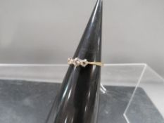 An unmarked yellow metal three stone diamond ring approx weight 2.9g