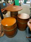 A pair of bound barrel seats with loose tops together with a similar taller barrel table