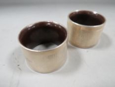 A pair of hallmarked silver bakelite lined napkin rings