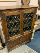 An oak leaded glazed linen fold bookcase