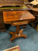 A Georgian mahogany fold over games table of small proportions W 60 cm