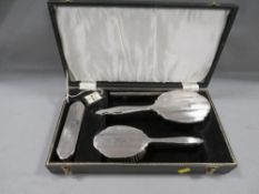 A cased four piece hallmarked silver dressing table set