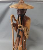 A large carved wooden figure of a man smoking a pipe