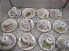 Set of twelve Months of the Year Caverswall miniature cups and saucers