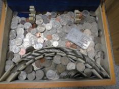 A wooden box of mixed coins