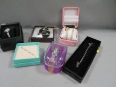 A small tray of boxed costume jewellery and watches
