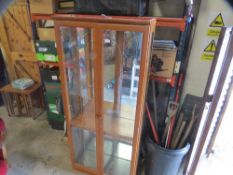 A modern display tall wall cabinet with glass shelves and light