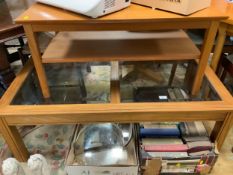 A glass top coffee table together with a smaller teak table