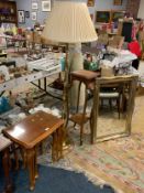 An oak plant stand with a brass effect standard lamp, gilt mirror and nest of tables