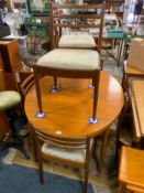 A mid-century teak extending dining table together with six chairs