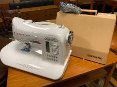 A cased Toyota electric service machine together with a cased Singer electric sewing machine, both