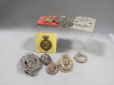 A quantity of military helmet plates and badges