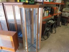 A glazed corner display cabinet with glass shelves, mirrored back and light