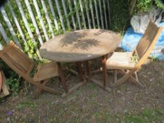 A round hardwood drop leaf garden table and two fold away chairs