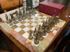 A modern onyx chessboard with gilt and silver colored pieces in an original Jaques chess box