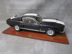 A DE AGOSTINI 1:8 SCALE DIE CAST MODEL OF A FORD MUSTANG 1967 SHELBY GT500, on a mahogany wooden