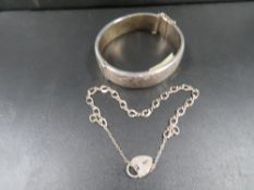 A hallmarked silver clasp bangle with a silver bracelet