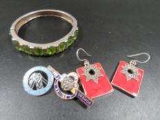 A modern 925 silver hinged bangle set with seven oval peridot faceted stones between marcasite set