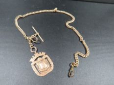 A hallmarked 9 carat gold fob on a hallmarked t- bar and watch chain - note chain has one