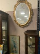 A modern oval gilt frame mirror together with a needlework picture