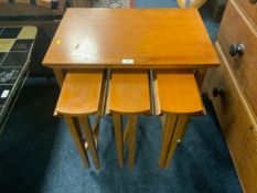 A mid-century teak nest of four tables