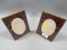 A pair of small gilt framed photograph frames with tortoiseshell mounts