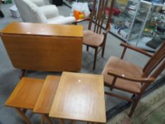 A teak dropleaf dining table and two carver dining chairs together with a retro Parker Knoll nest of