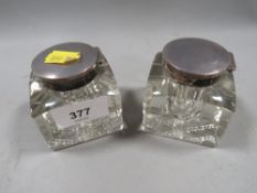 A pair of hallmarked silver topped inkwells