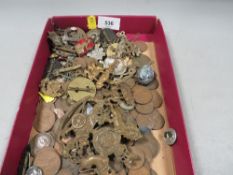 A tray of collectables to include military cap badges , coins etc